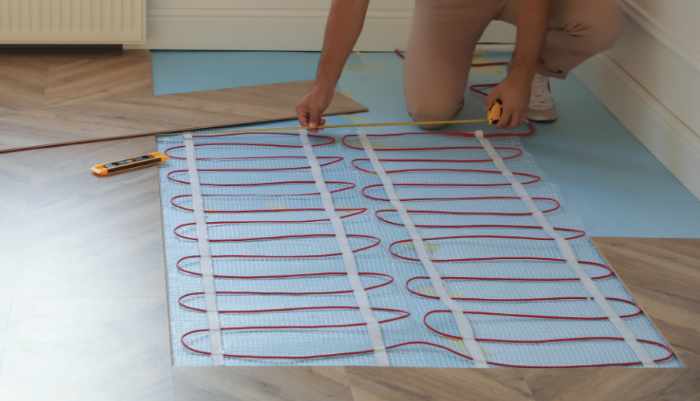 Professional worker installing electric underfloor heating syste
