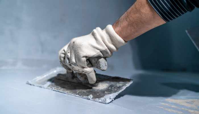 manual application of waterproofing to the wall on the construct