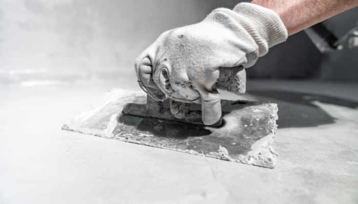 spreading the insulation on the concrete with a trowel