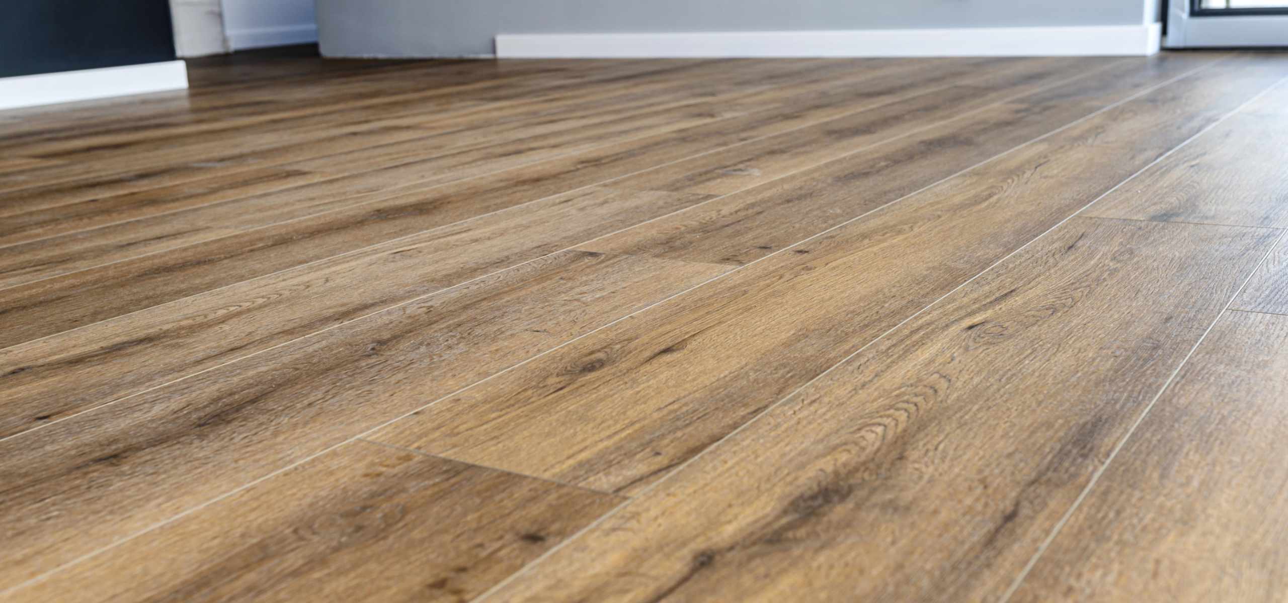 Modern vinyl panels imitating wood in the living room with selective focus and a shadow falling from the window.