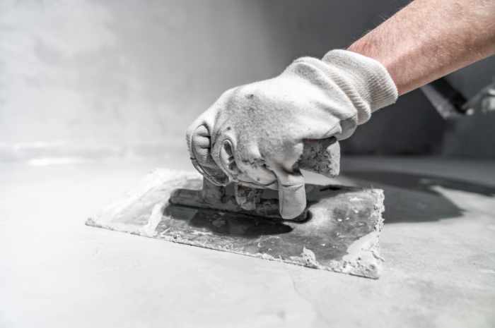 spreading the insulation on the concrete with a trowel